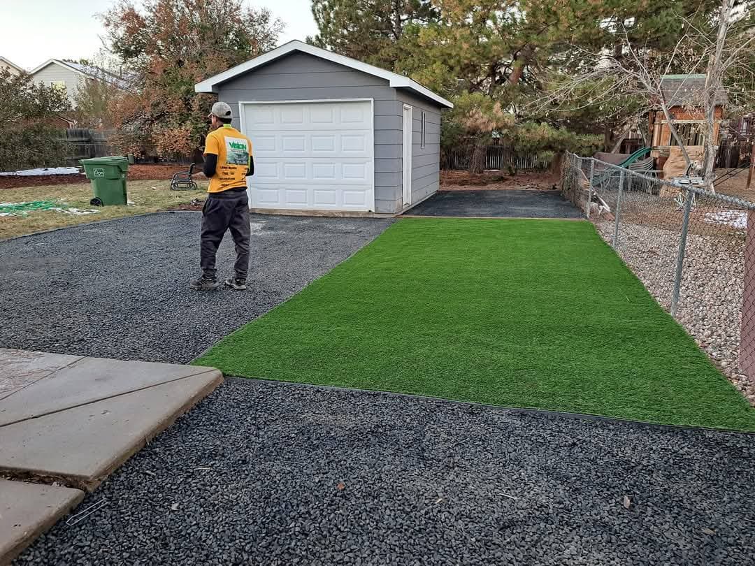 Worker installing artificial turf in residential yard
