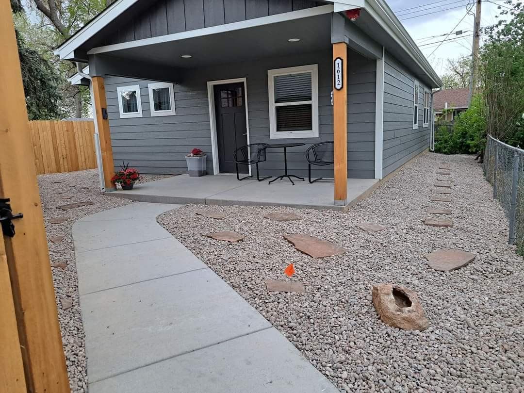 Modern tiny home exterior with gravel landscaping and concrete walkway