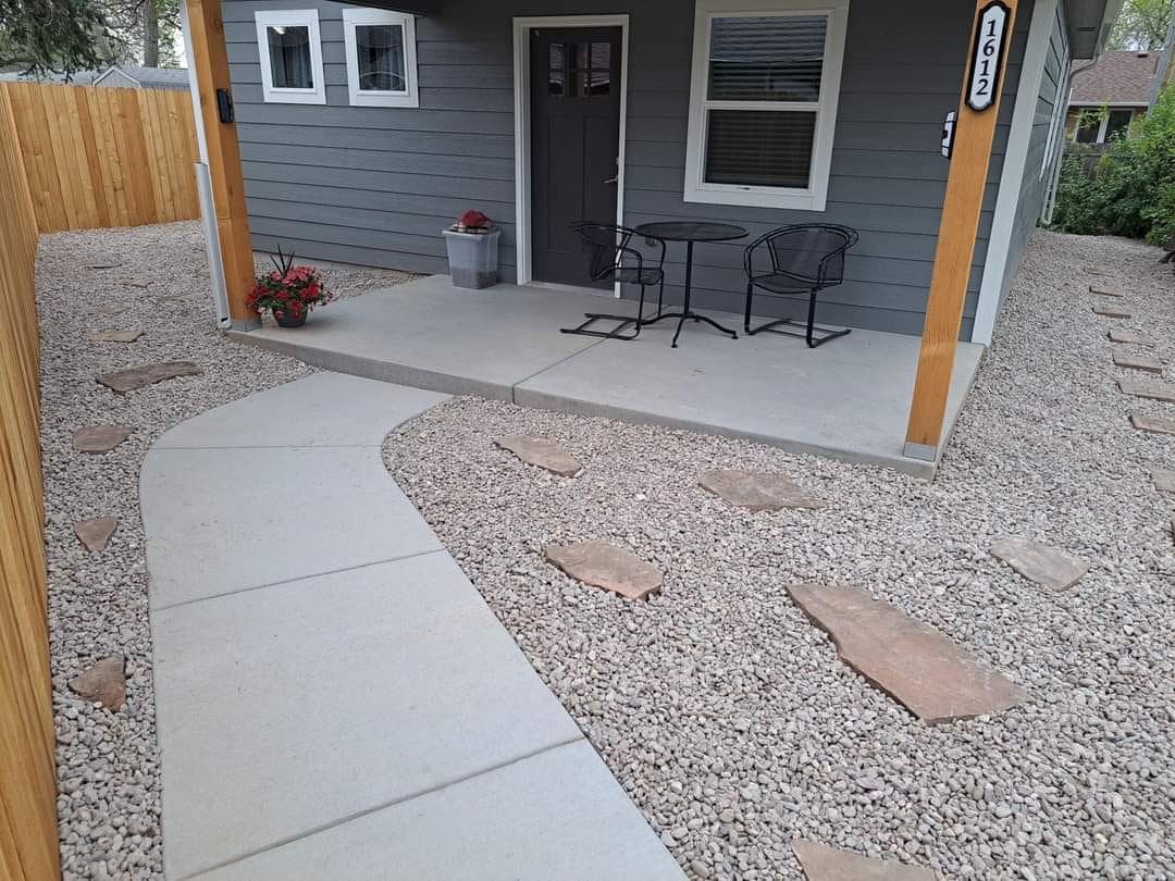 Modern home porch and pathway with concrete walkway, gravel and potted plants
