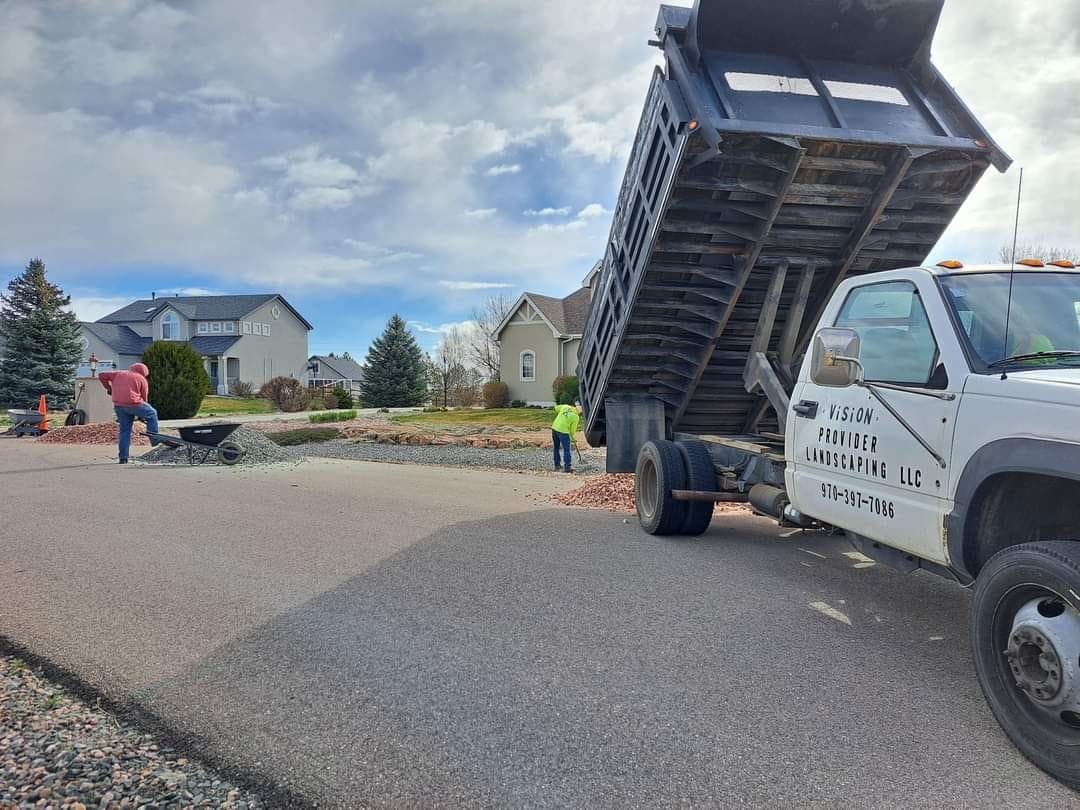 Dump truck unloading gravel with workers and excavator
