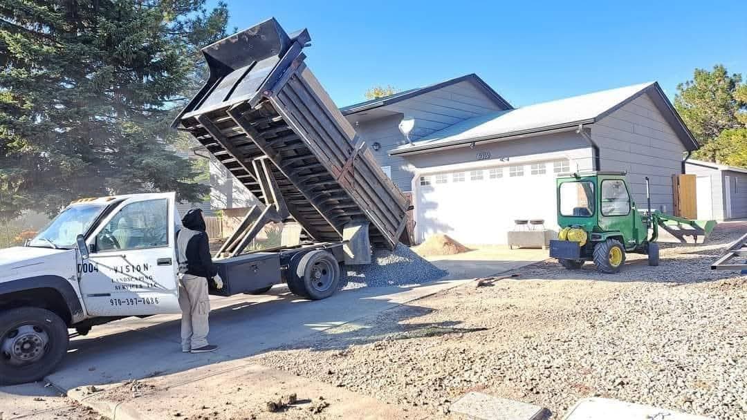 Dump truck unloading gravel onto residential property
